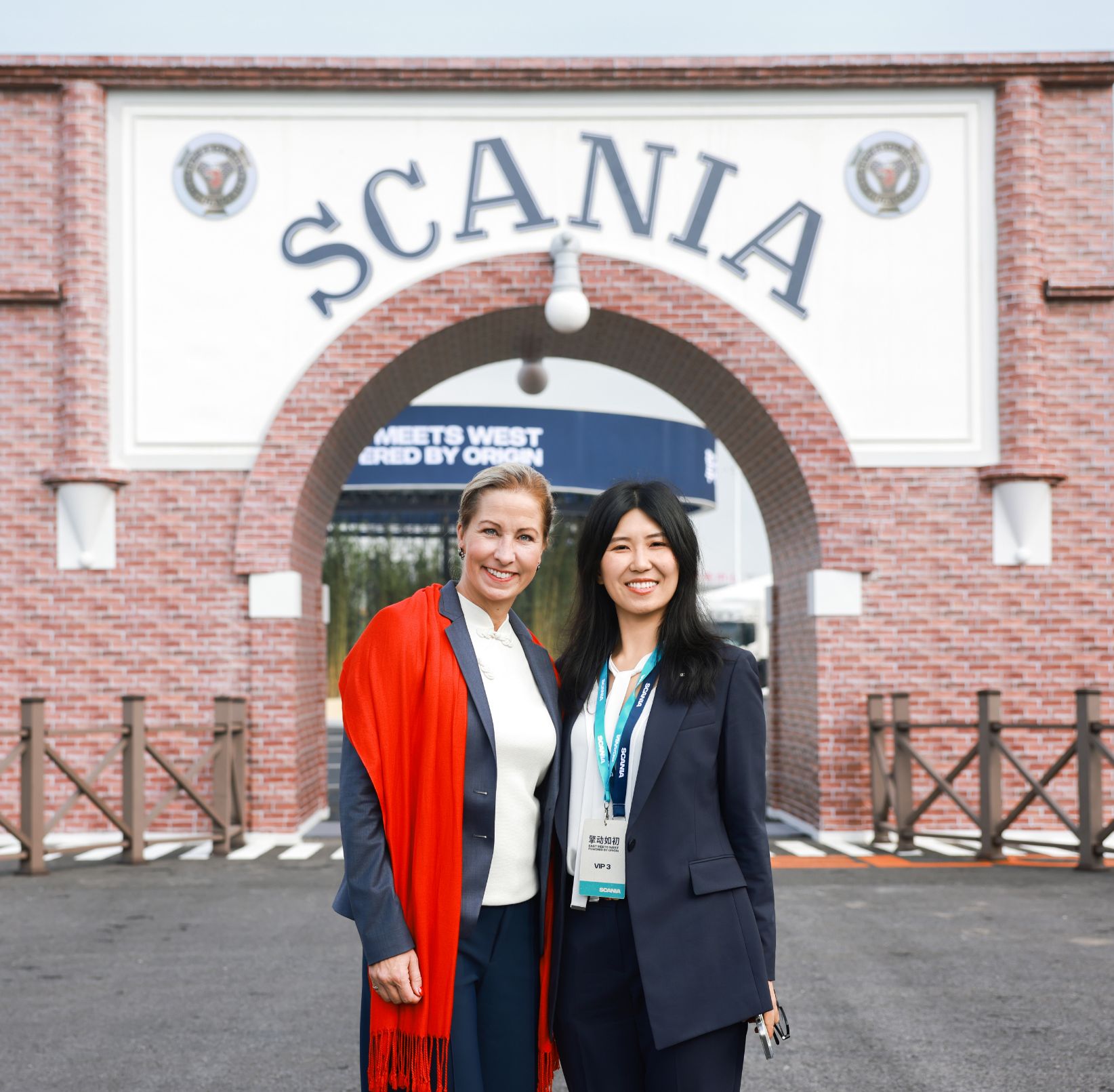 Camilla Dewoon (left) and Zita Shao (right), Senior Corporate Communication Manager in front of Scania's historic logo in Rugao.